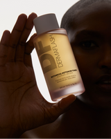 COMPLETE SONIC SKINCARE SET - Pop Pink | model holding BOTANICAL KETOACID TONER with low lighting from the Complete Sonic Skincare Set in Pop Pink