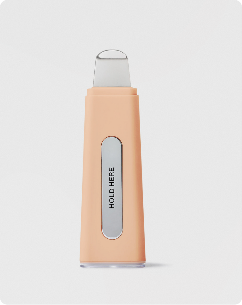 Peach Fuzz | DERMAPORE+ pore extractor tool in Peach Fuzz showing Hold Here text on device