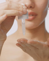HYDRAFLASH COCOONING SERUM™ - Model dispensing  COCOONING SERUM from dropper and applying to her face 